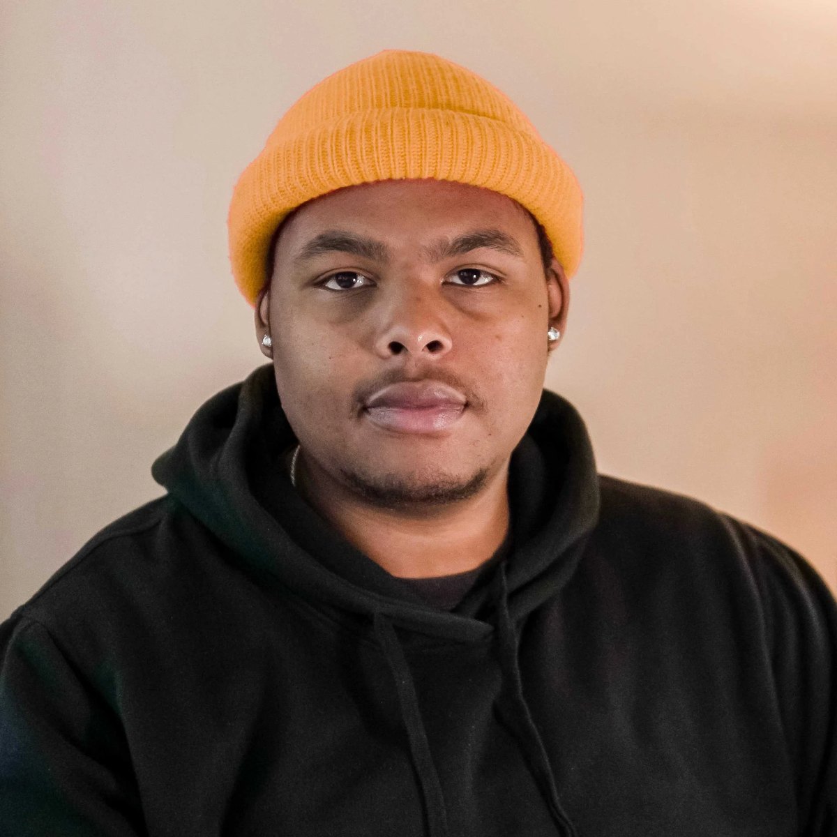 Isaiah G wearing a yellow beanie and black hoodie